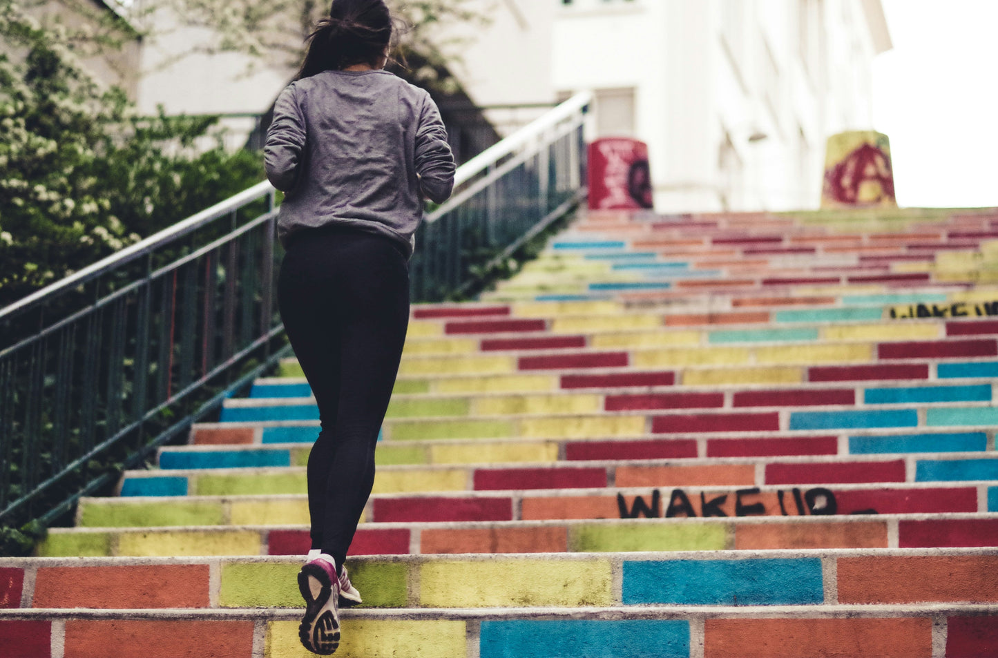 Person jogging up colorful stairs with "WAKE UP" written on them, emphasizing the need for reliable Deodorants for Sensitive Skin to stay confident and odor-free during vigorous activities