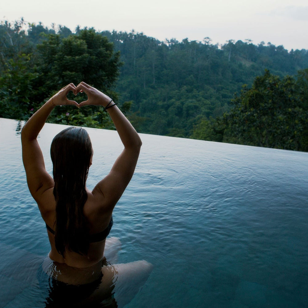 Confident woman raising her arms fearlessly, using scented or unscented deodorant for all-day assurance.