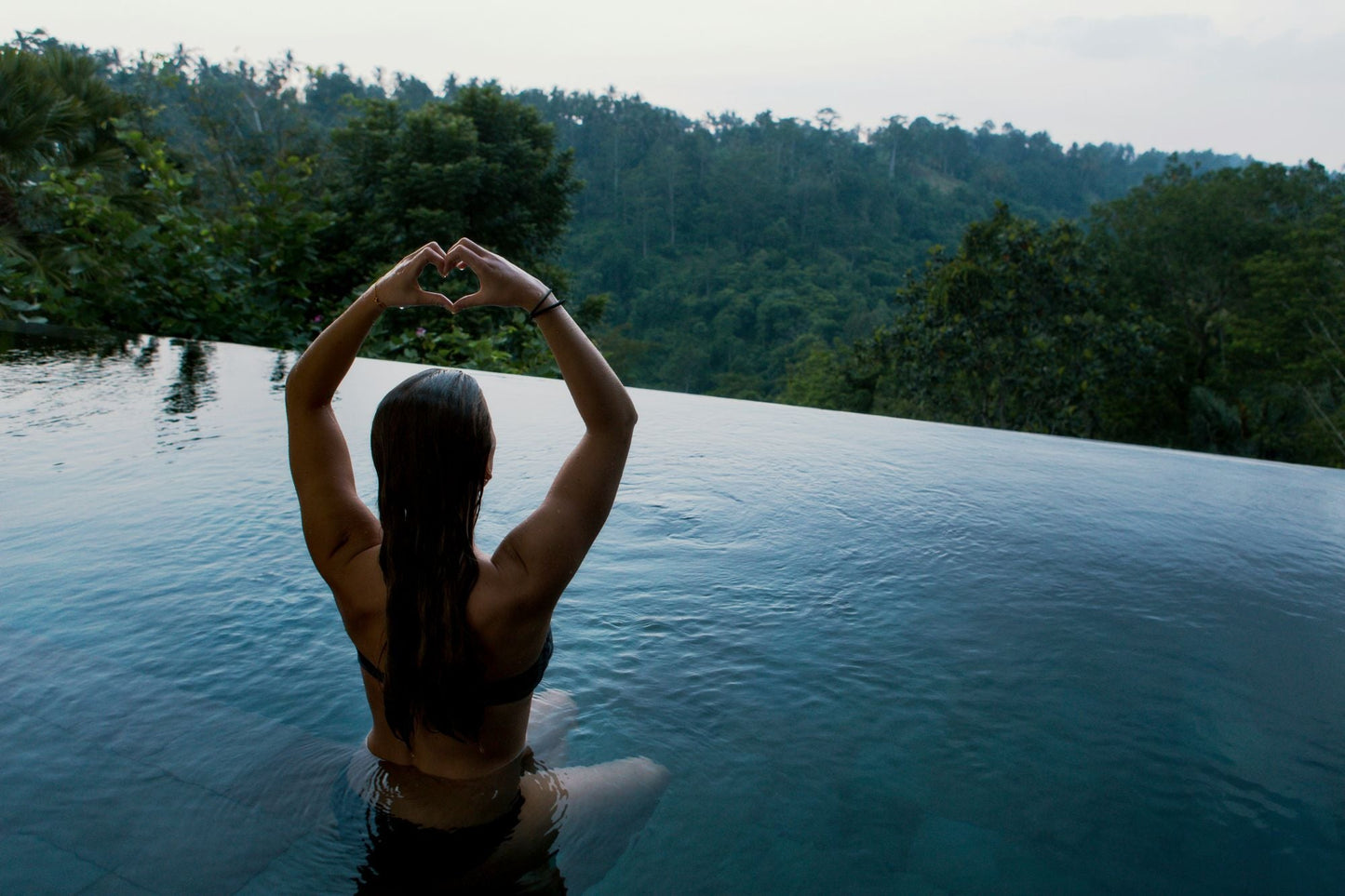 Confident woman raising her arms fearlessly, using scented or unscented deodorant for all-day assurance.